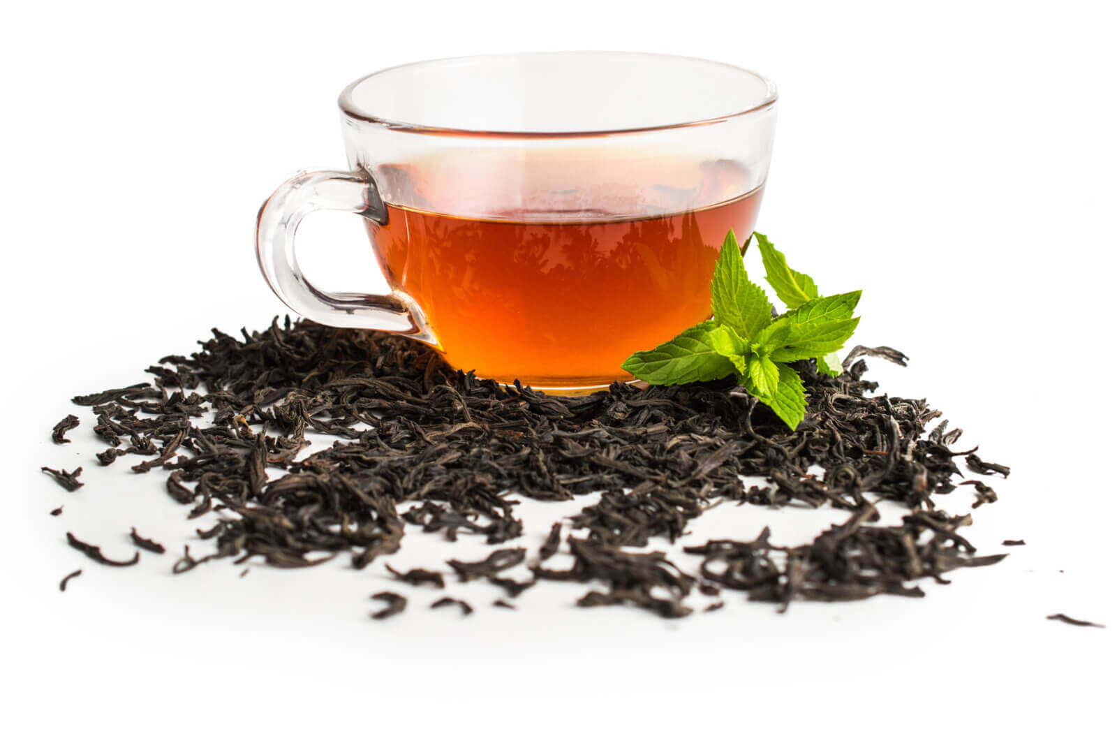 Tea Leaves surrounding a glass of black tea