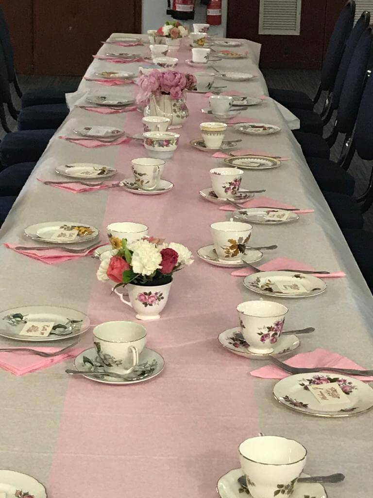 Photo shows a long table with vintage china ready for an Afternoon Tea Party